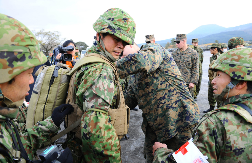 Japanese soldiers try on the bulletproof vest and first-aid equipment of U.S. Marines during ground medical-aid training in Kirishima Training Area in southern Japan&apos;s Miyazaki Prefecture, Dec. 7, 2010. [Xinhua]