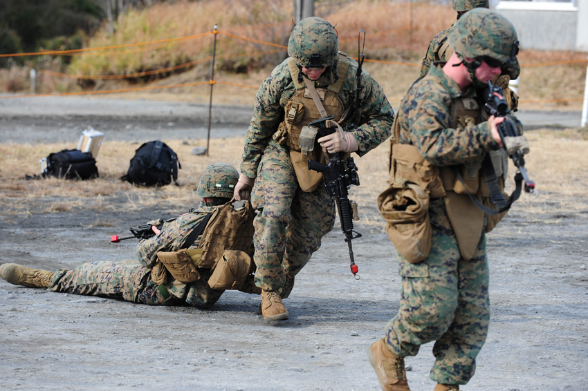 U.S. Marines help mock wounded comrade during ground medical-aid training in Kirishima Training Area in southern Japan&apos;s Miyazaki Prefecture, Dec. 7, 2010. [Xinhua]