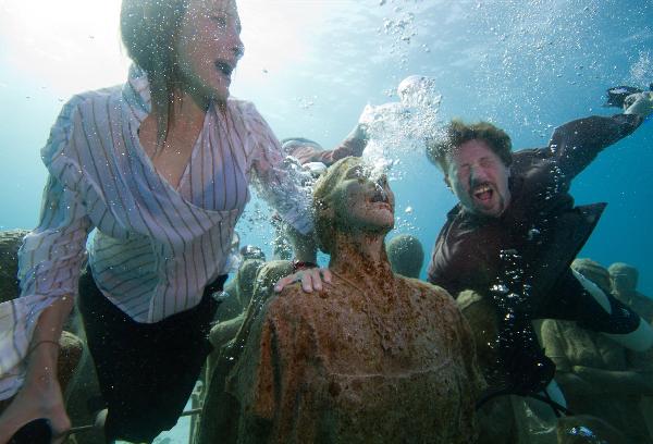 Young people dressed in everyday wear, dive amongst the statues at the underwater art installation, Silent Evolution in Cancun, Mexico, on Dec. 6, 2010. TckTckTck partners, Greenpeace and 350.org, staged a haunting underwater tableau to highlight the need for urgent action as the UN Cancun climate talks went into their second week. [Xinhua] 