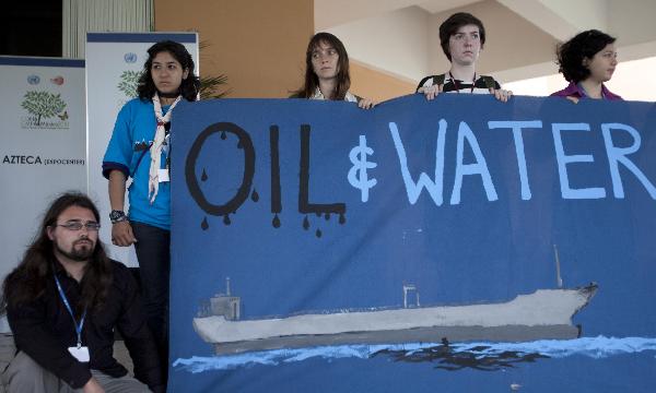 Canadian activists hold a banner during a rally outside the United Nations Climate Change Conference in Cancun, Mexico, on Dec. 6, 2010. [Xinhua]