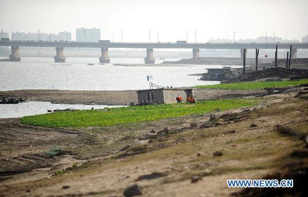 Residents plant vegetables on dried riverbed of the Ganjiang River at the northern bank in Nanchang, east China's Jiangxi Province, Dec. 7, 2010. Water levels of main rivers and lakes in Jiangxi continuously dropped due to the rainfall decrease which happened since late October. About 230 thousand residents in the range of the province, especially in the cities along the Ganjiang River such as Nanchang, Fengcheng, Zhangshu, are suffering from the lack of drinking water. 