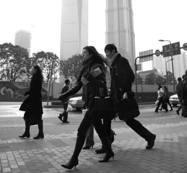 White-collar workers walk to work in Shanghai. Provided to China Daily