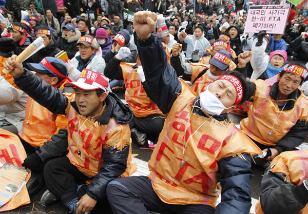 South Korean farmers chant anti-government slogans during a rally denouncing the US-South Korea Free Trade Agreement (FTA) in Seoul Dec 8, 2010. US and South Korean negotiators struck a deal last week on the long-delayed FTA, which was signed in 2007 but had not been ratified for three years because of US auto and beef industry concerns. [China Daily/Agencies]