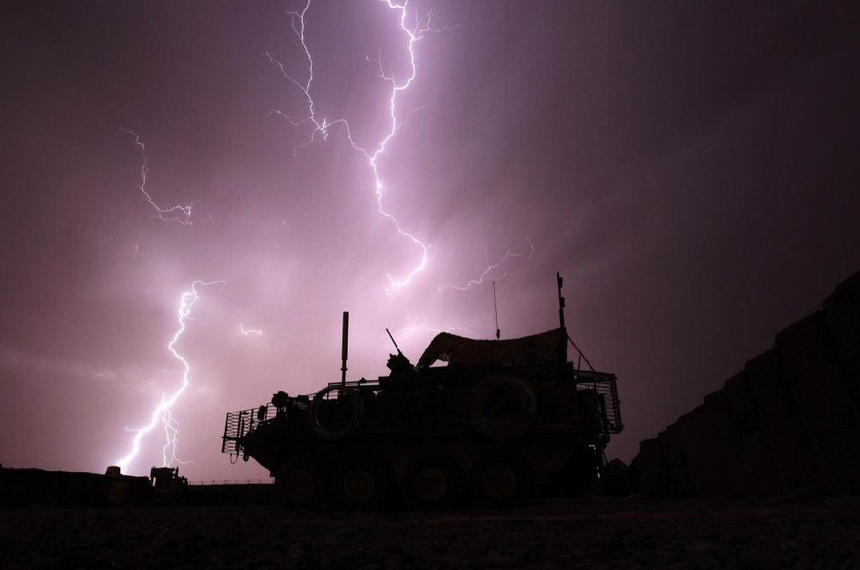 An armoured vehicle from the Centurion Company, 2-1 Infantry Battalion, 5/2 Stryker Brigade Combat Team is framed by a bolt of lightning during a storm at Combat Outpost Terminator in Maiwand District, Kandahar Province April 19, 2010.[China Daily/Agencies]