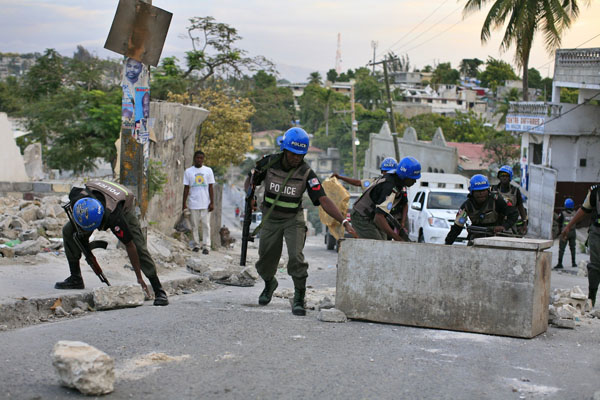 UN police officers remove barricades set up by protesters in Port-au-Prince Dec. 8, 2010. Thousands of protesters rampaged through the streets of Haiti's capital on Wednesday to contest results of national elections, and set fire to the headquarters of the ruling government coalition they accuse of rigging the results, witnesses said. [Xinhua]