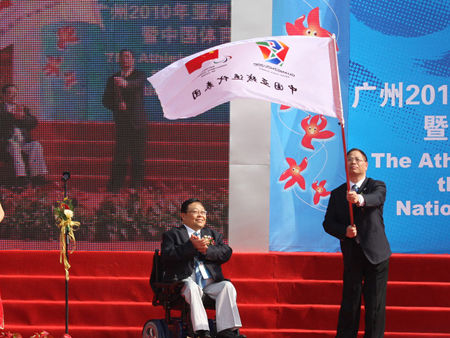 Wang Xinxian (right), President of the China Disabled Persons' Federation (CDPF), President of the National Paralympic Committee of China and Executive President of the Guangzhou Asian Para Games Organising Committee (GAPGOC), presents the flag of the Chinese sports delegation to Chef de Mission Lv Shiming. 