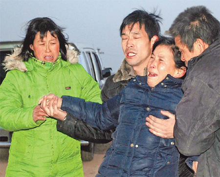 Relatives of a miner killed in a gas explosion are overcome by grief on Wednesday in Mianchi county, Henan province. The blast, which killed 26 miners, occurred at 5:40 pm on Tuesday at Juyuan Coal Mine in Mianchi. [Photo by Yu Fen / China News Service]    