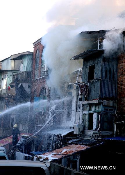 Fire fighters put out fire in residential apartments in Xiamen, southeast China&apos;s Fujian Province, Dec. 9, 2010. Fire broke out in the apartments at approximately 9:00 a.m. Thursday. Two people were confirmed dead by 10:00 am. The cause of the fire is still under investigation. [Xinhua]