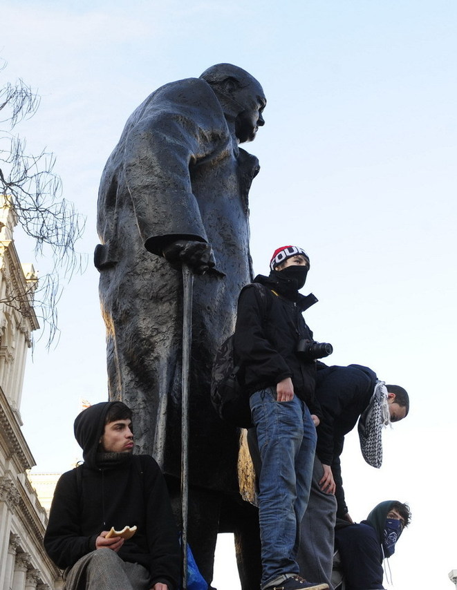 Protesters occupy the statue of Winston Churchill in front of the Parliament Building in London, Britain, Dec. 9, 2010. [Xinhua] 