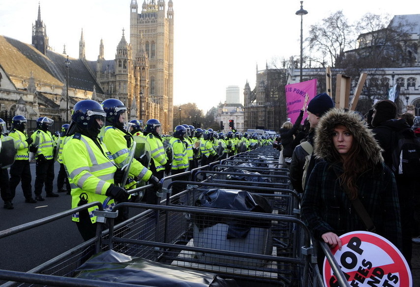 Protesters confront the police in front of the Parliament Building in London, Britain, Dec. 9, 2010. [Xinhua]