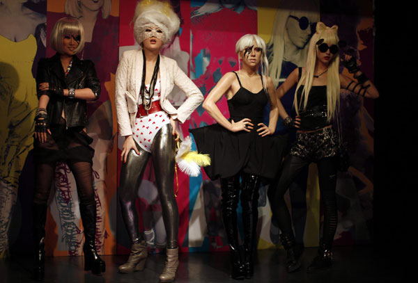 Models pose with a wax statue of Lady Gaga, wearing a short black Orchel-Read trousers with black top, thigh high patent boots and black lightning stripe make up over one eye, at the Madame Tussauds Wax Museum in Shanghai, Dec 9, 2010. [China Daily/Agencies] 