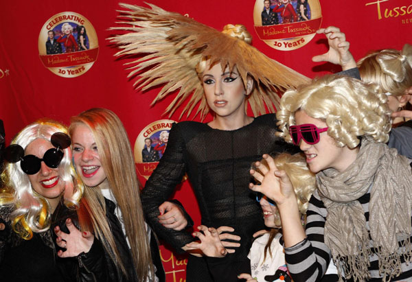 A wax figure of US singer Lady Gaga is surrounded by fans after its unveiling at Madame Tussauds museum in New York, Dec 9, 2010. New York joins seven other Madame Tussauds attractions around the world in revealing new Lady Gaga figures on Thursday. [China Daily/Agencies] 