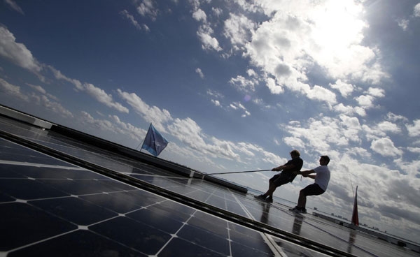 People work on the world&apos;s largest solar-powered boat in Cancun December 8, 2010. The Turanor Planet Solar arrived in Cancun on Dec 6 as part of its expedition around the globe and as climate talks are under way in the beach resort. [China Daily/Agencies] 