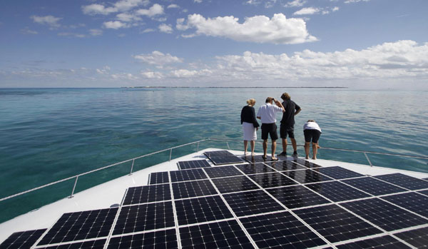 People stand on the world&apos;s largest solar-powered boat in Cancun Dec 8, 2010. The Turanor Planet Solar arrived in Cancun on December 6 as part of its expedition around the globe and as climate talks are underway in the beach resort. [Photo/Xinhua]