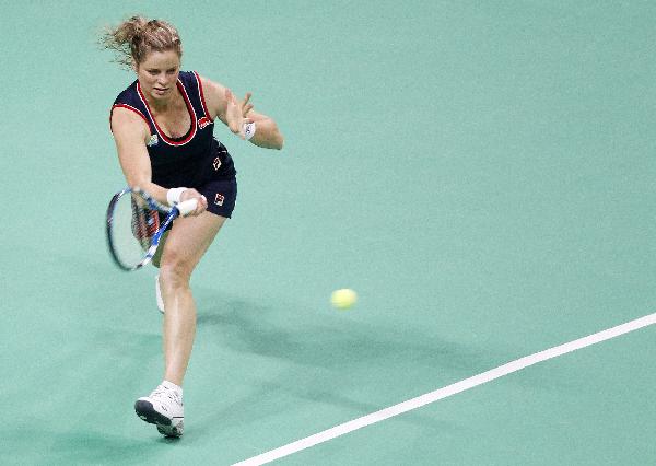 Kim Clijsters of Belgium returns the ball to Justine Henin during their Diamond Games exhibition match in Antwerp December 9, 2010. [Xinhua/Reuters]