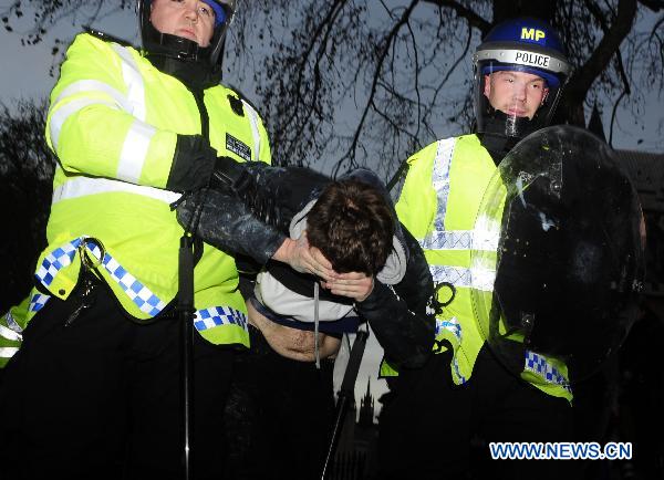 A protester is arrested in London, Britain, Dec. 9, 2010. Over 20,000 students took to streets to protest against the coalition government's plan to raise the tuition fees cap in England from 3290 to 9,000 pounds per year, which was passed in the House of Commons Thursday. More than a dozen of policemen and students have been injured during the clash. [Zeng Yi/Xinhua]