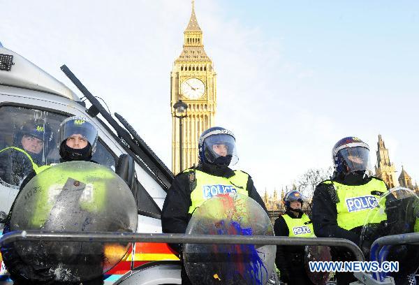 Policemen whose shields were spilled with paint thrown by protesters stand guard in front of the Parliament Building in London, Britain, Dec. 9, 2010. [Zeng Yi/Xinhua] 
