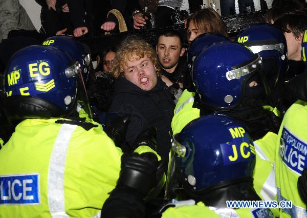Policemen try to push a protester back in London, Britain, Dec. 9, 2010. [Zeng Yi/Xinhua]