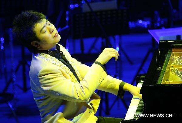 Renowned Chinese young pianist Lang Lang performs during his new year concert in Nantong, east China's Jiangsu Province, Dec. 10, 2010. [Ding Xiaochun/Xinhua]