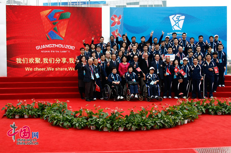 Members of China's Hong Kong delegation attend the national flag raising ceremony at the Athletes&apos; Village of the Guangzhou 2010 Asian Para Games in Guangzhou, capital of south China&apos;s Guangdong Province, Dec. 11, 2010. [Zhao Na/ China.org.cn]