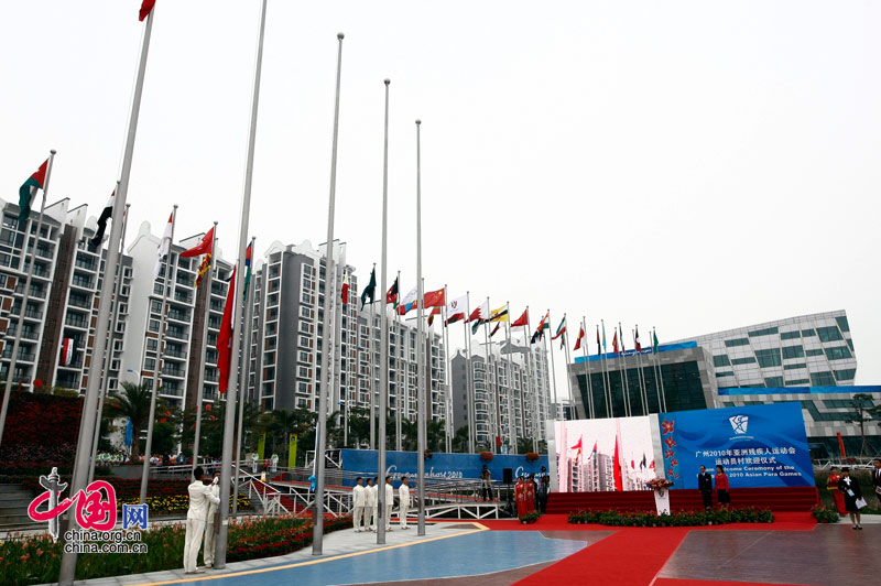 Members of China's Hong Kong delegation attend the national flag raising ceremony at the Athletes' Village of the Guangzhou 2010 Asian Para Games in Guangzhou, capital of south China's Guangdong Province, Dec. 11, 2010. [Zhao Na/ China.org.cn]