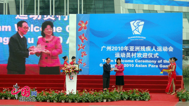 Ms Kong Shaoqiong, Mayor of the Athletes' Village, presents gifts to China's Hong Kong delegation at the Athletes' Village of the Guangzhou 2010 Asian Para Games in Guangzhou, capital of south China's Guangdong Province, Dec. 11, 2010. [Zhao Na/ China.org.cn]