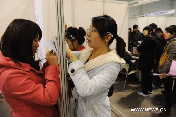 Job seekers fill in a form during a recruitment fair held at Anhui International Exhibition and Conference Center in Hefei, capital of east China&apos;s Anhui Province, Dec. 11, 2010. Five hundred enterprises provided more than 20,000 job vacancies at the recruitment fair on Saturday. [Xinhua]