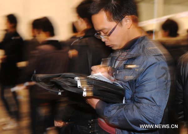 A job seeker fills in a form during a recruitment fair held at Anhui International Exhibition and Conference Center in Hefei, capital of east China&apos;s Anhui Province, Dec. 11, 2010. Five hundred enterprises provided more than 20,000 job vacancies at the recruitment fair on Saturday. [Xinhua]