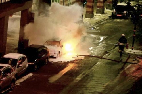 A still image taken from a video footage shows a firefighter attempting to put out the fire on a burning car in Stockholm December 11, 2010. [China Daily/Agencies]