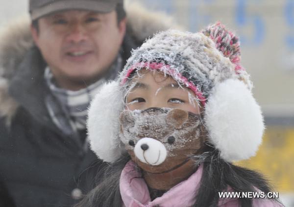 A child wearing a mask is seen in the snow in Genhe, north China&apos;s Inner Mongolia Autonomous Region, Dec. 12, 2010. Temperature in Genhe hit as low as minus 45 degrees Celsius on Sunday, according to local meteorological authorities. A sharp temperature drop of more than ten degrees Celsius, caused by recent cold snaps, was recorded in the city. [Xinhua] 