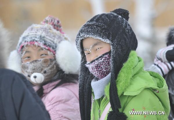 Children wearing masks are seen in the snow in Genhe, north China&apos;s Inner Mongolia Autonomous Region, Dec. 12, 2010. Temperature in Genhe hit as low as minus 45 degrees Celsius on Sunday, according to local meteorological authorities. A sharp temperature drop of more than ten degrees Celsius, caused by recent cold snaps, was recorded in the Inner Mongolian city. [Xinhua]