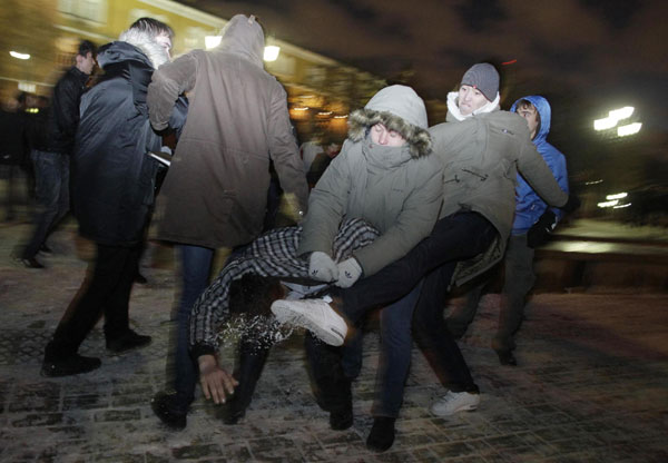 Right-wing protesters beat a passer-by of a non-Slavic appearance in central Moscow Dec 11, 2010. [China Daily/Agencies]