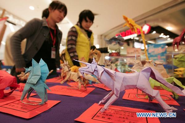 Visitors view paper folding works during an exhibition in Hangzhou, capital of east China&apos;s Zhejiang Province, Dec. 11, 2010. Some 150 paper folding works created by more than 20 makers were displayed here on Saturday. [Xinhua] 