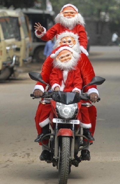 People dressed as Santa Claus ride on a motorbike ahead of Christmas celebrations in the southern Indian city of Chennai Dec 11, 2010.[China Daily/Agencies] 