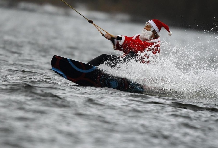 A man dressed as Santa Claus wakeboards at a water ski set on a small lake in Hamburg Dec 5, 2010. [China Daily/Agencies] 