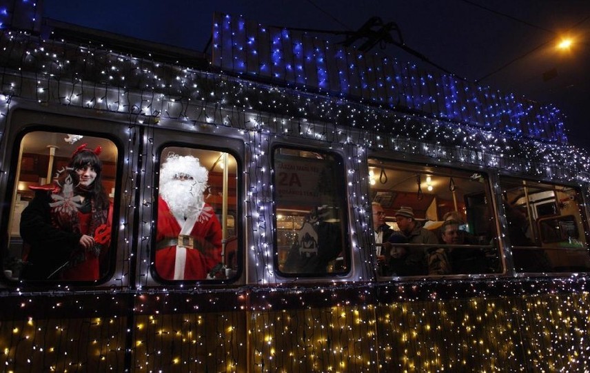 A man dressed as Santa Claus and a woman dressed as mythical creature Krampus travel in a tram decorated with Christmas lights in the centre of Budapest Dec 3, 2010. [China Daily/Agencies] 