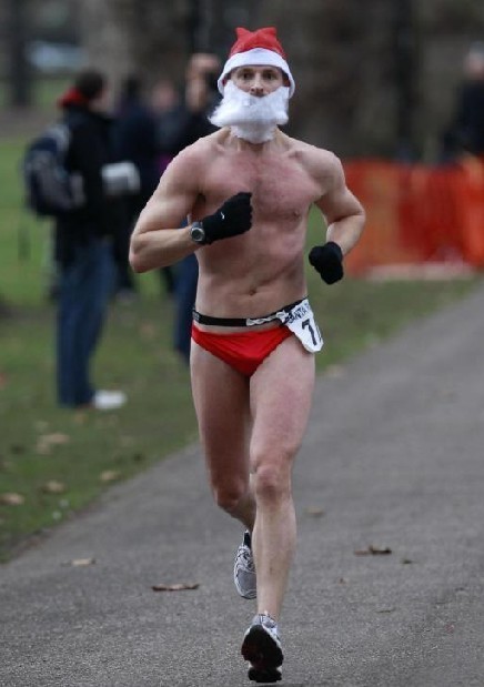 A runner wears a Santa Claus hat and beard as he takes part in the annual Santa Run in Battersea Park, in London, Dec 11, 2010. [China Daily/Agencies] 