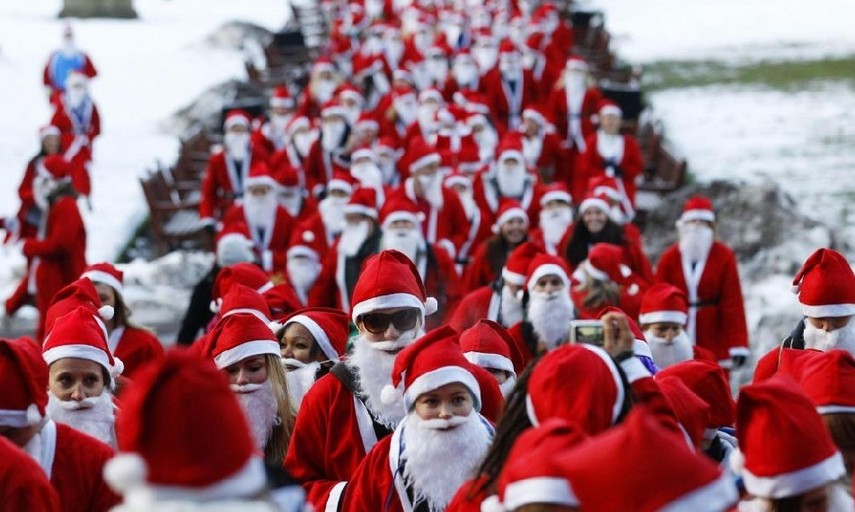 People dressed in Santa Claus outfits jog together during The Great Scottish Santa Run in Princes Street gardens in Edinburgh, Scotland Dec 12, 2010. [China Daily/Agencies] 