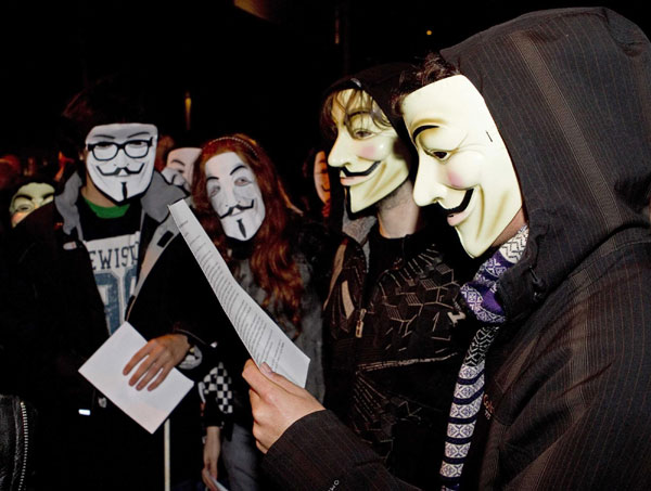  WikiLeaks supporters read a manifesto in support of WikiLeaks founder Julian Assange and wear masks of the &apos;Anonymous&apos; Internet activist group during a demonstration in front of the British Embassy in Madrid Dec 11, 2010. [China Daily/Agencies] 