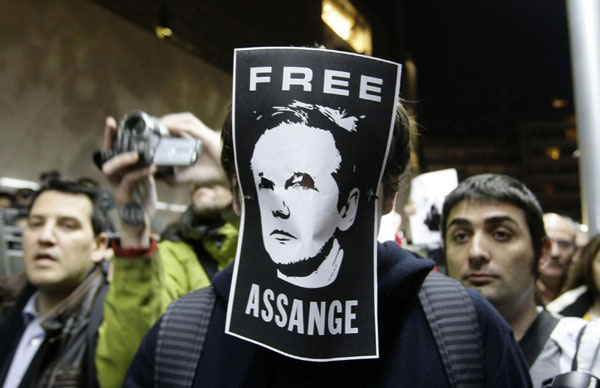 A protester wears a picture as a mask in support of WikiLeaks founder Julian Assange during a demonstration in front of the British Consulate in Barcelona Dec 11, 2010.[China Daily/Agencies]