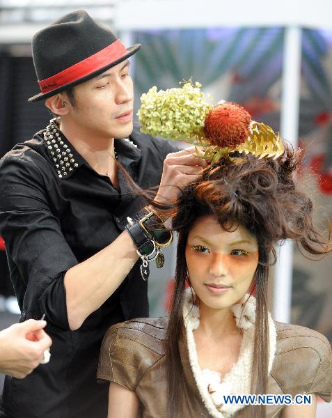 A hairstyle designer sets up ornaments on a model's hair during a hairstyle show held in the Far East Fashion Pavilion at the Flora Expo in Taipei, southeast China's Taiwan, Dec. 12, 2010.