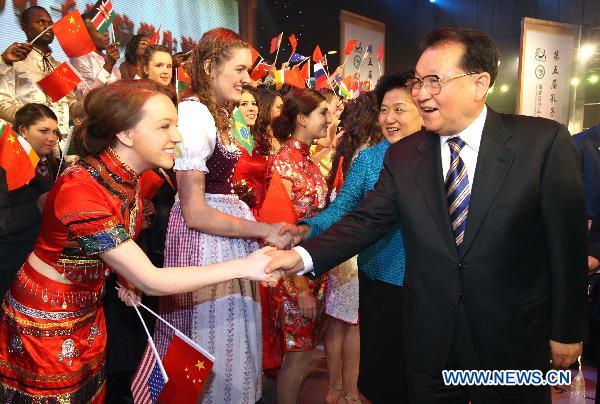 Li Changchun (R), Standing Committee member of the Political Bureau of the Communist Party of China (CPC) Central Committee, shakes hands with the awarded student at the opening ceremony of the fifth conference of Confucius Institutes in Beijing, capital of China, on Dec. 10, 2010.