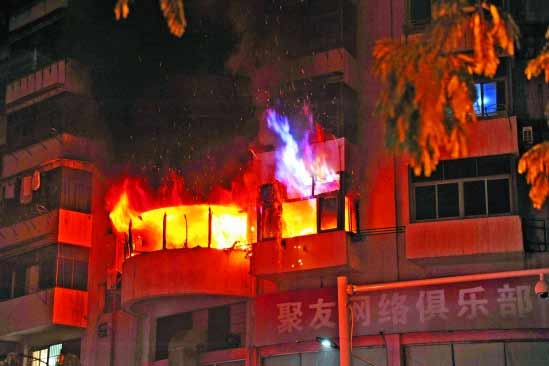 The photo taken on Monday, Dec 13, 2010 shows burning fire at chess-and-card room of an apartment building at downtown of Quzhou city in east China&apos;s Zhejinag province, which killed nine people and injured two. Along with an explosion, the fire broke out at 8:10 p.m. on the building&apos;s third floor at downtown of Quzhou city. [Qianjiang Evening News]