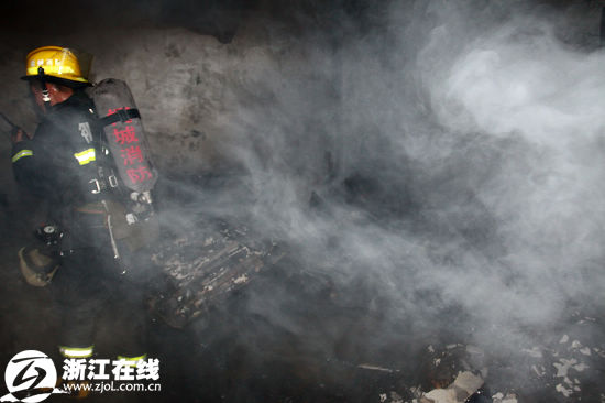 Firemen work at the scene where nine people were killed and two injured in a fire at a chess-and-card room of Quzhou city in East China&apos;s Zhejiang Province on Monday, Dec 13, 2010. [Qianjiang Evening News]