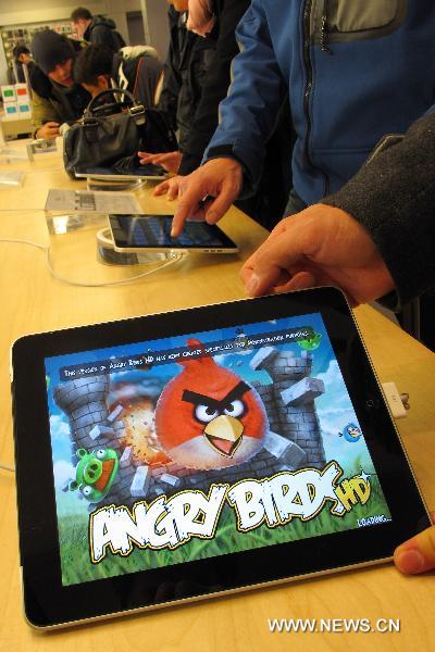Customers play the &apos;Angry Birds&apos; on iPads at the flagship store of Apple Inc. in New York, the United States, Dec. 12, 2010. The addictive game &apos;Angry Birds&apos; was named as the No. 1 selling app. of 2010 for iTunes. The game features the revenge of the Angry Birds on the green pigs who stole the Birds&apos; eggs. [Xinhua] 