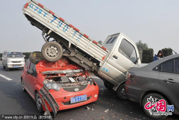 A car is mounted by a light truck on a highway in one of the 52 car pile-ups in Chengdu, Southwest China&apos;s Sichuan province, Dec 13, 2010. [CFP]