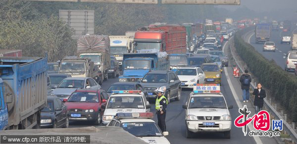 A policeman works on a highway after 52 car pile-ups in Chengdu, Southwest China&apos;s Sichuan province, Dec 13, 2010. [CFP]