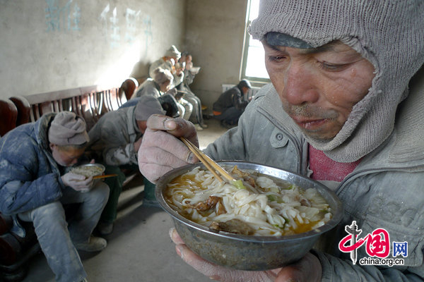 Mentally ill workers have dinner in a room at the Jiaersi Green Construction Material Chemical Factory in Toksun county, Northwest China&apos;s Xinjiang Uygur autonomous region. [CFP] 