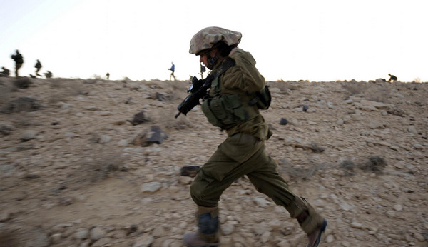 A female Israeli Defense Force (IDF) soldier takes part in a drill in desert near Israel-Egypt border and Israeli Southern City of Sede Boker, on Dec 13, 2010. [Xinhua]