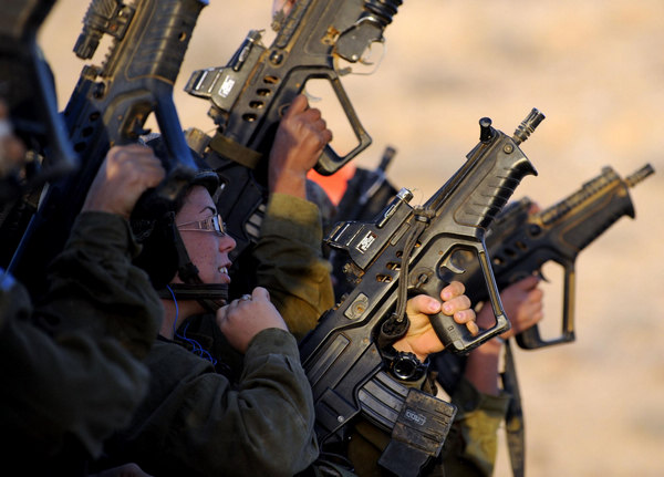 Female Israeli Defense Force (IDF) soldiers take part in a drill in a desert near Israel-Egypt border and Israeli Southern City of Sede Boker, on Dec 13, 2010.[China Daily/Agencies]